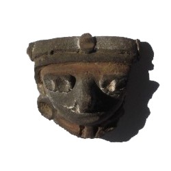 Cara pequeño de barro con pintura roja.